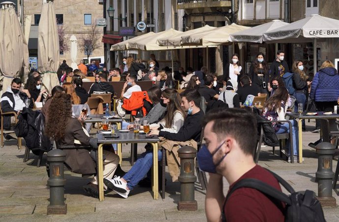 Varias personas en la terraza de un restaurante durante el primer día de la apertura parcial de la hostelería en Santiago de Compostela, A Coruña, Galicia (España), a 26 de febrero de 2021. La Xunta de Galicia reabre desde hoy parcialmente la hostelería