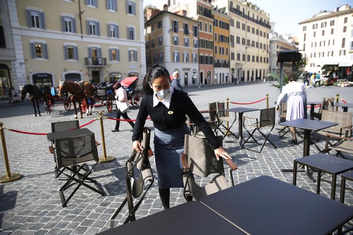 26 February 2021, Italy, Rome: An employee prepares tables in the outdoor area of a cafe near the Spanish Steps. In Italy, the number of people who have died with or from a Corona infection in one day has dropped again. Photo: Cecilia Fabiano/LaPresse v