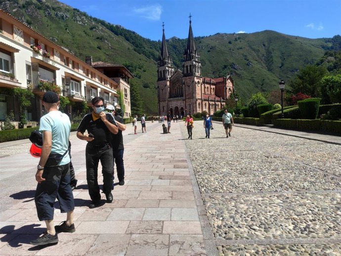 Archivo - Turistas paseando en el Santuario de Covadonga con mascarillas este verano.