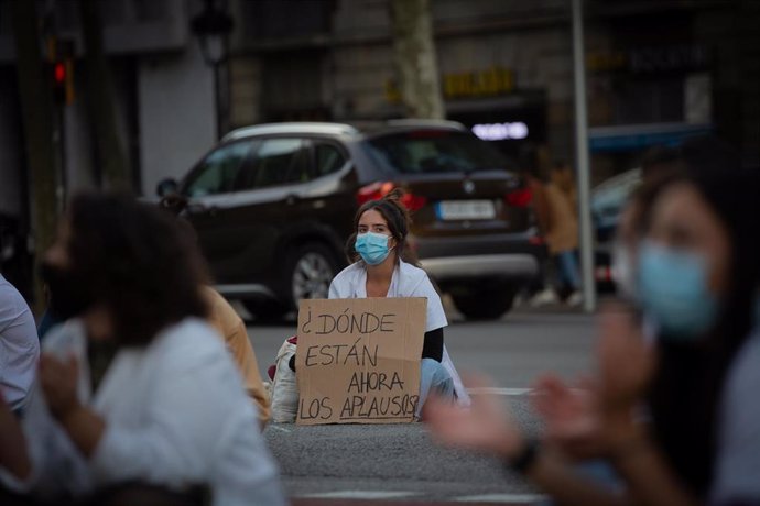 Archivo - Una profesional sanitaria sostiene un cartel en el que se lee '¿Dónde están ahora los aplausos?' en una concentración de Médicos Internos Residentes (MIR) en Barcelona