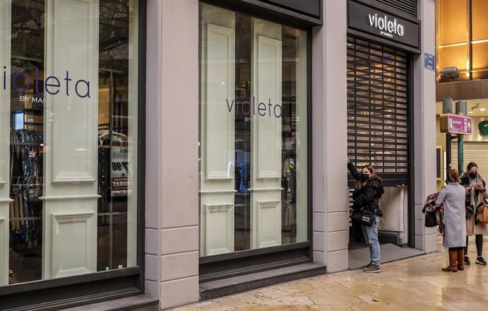 Archivo - Una trabajadora del comercio Violeta cierra el establecimiento el primer día del cierre total de la hostelería y de tiendas a las 18.00h en Valencia, Comunidad Valenciana (España), a 21 de enero de 2021.