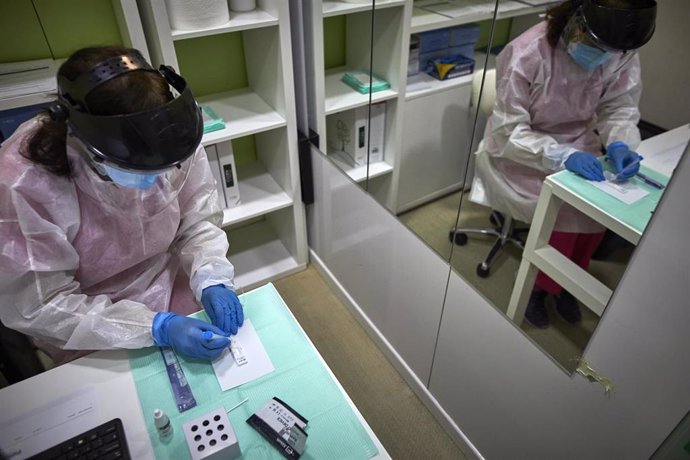 Una farmacéutica comprueba si la persona a la que le ha realizado el test de antígenos es positiva o negativa por Covid-19 en la Farmacia Las Gemelas en Madrid (España)