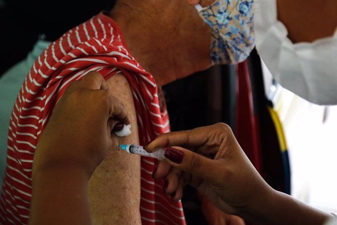 25 February 2021, Brazil, Rio de Janeiro: A health worker administers a shot of a COVID-19 vaccine for an elderly at a drive-thru COVID-19 vaccine centre in Rio de Janeiro State University. Photo: Tnia Rgo/Agencia Brazil/dpa
