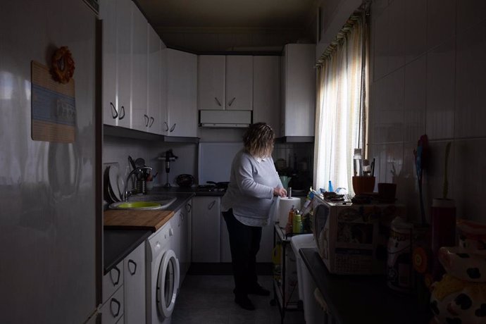 Una mujer realizando tareas del hogar en la cocina