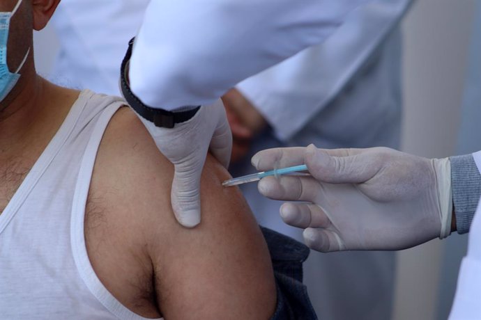 02 February 2021, Palestinian Territories, Bethlehem: A Palestinian health worker receives a Moderna Coronavirus (Covid-19) vaccine. Palestinian Authority began vaccinating health workers after a global pressure campaign on Israel to provide the vaccine