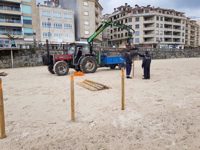 Retirada de las estacas y las cuerdas de las parcelas de la playa de Silgar, en Sanxenxo (Pontevedra).