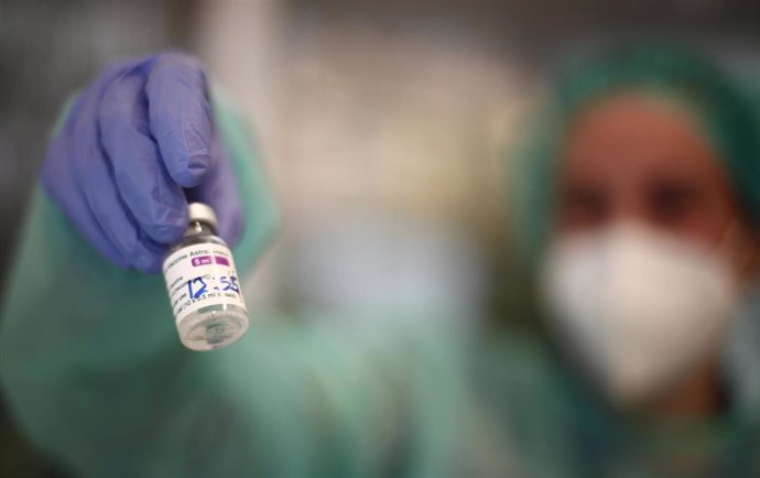 Un profesional sanitario sostiene un vial de la vacuna de AstraZeneca contra la COVID-19, en la sede del Colegio Oficial de Farmacéuticos de Madrid (COFM), en Madrid.