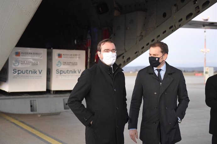 El primer ministro de Eslovaquia, Igor Matovic (D) y el ministro de Salud,  Marek Krajci (I), posan en el aeropuerto de la ciudad de Kosice ante el primer envío de vacunas Sputnik V llegado al país.