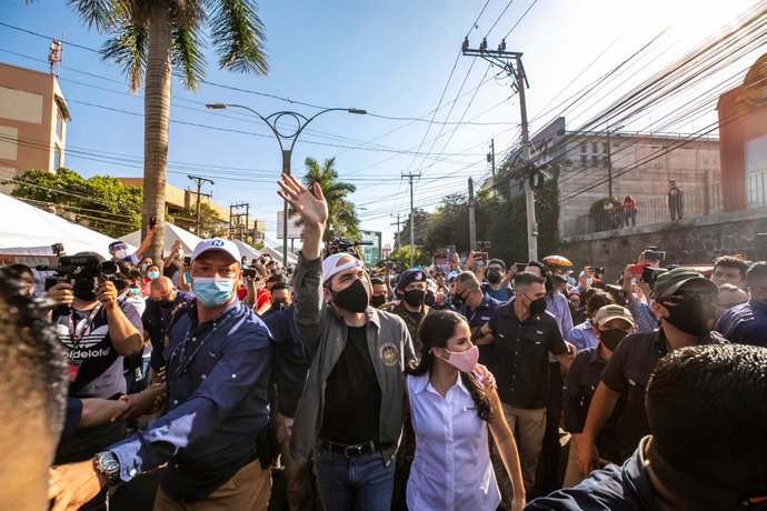 HANDOUT - 28 February 2021, El Salvador, San Salvador: Nayib Bukele (C), President of El Salvador, waves to supporters as he arrives at a polling station with his wife Gabriela Rodriguez (C-R) during the local and legislative elections in El Salvador. P