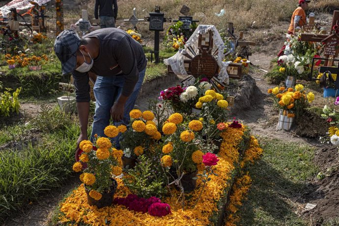 Archivo - 31 October 2020, Mexico, Chalco: A man decorates his relatives' graves with flowers, ahead of the Mexican Festival Day of the Dead. Photo: Jacky Muniello/dpa