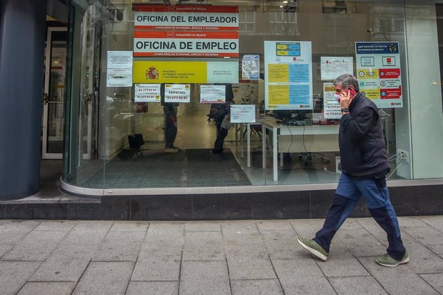 Archivo - Una persona pasa por delante de una Oficina de Empleo ubicada en la capital, en Madrid