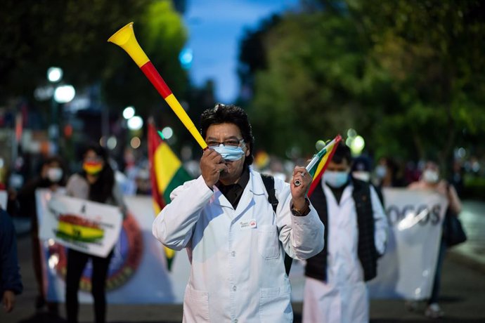 23 February 2021, Bolivia, La Paz: A doctor takes part in a demonstration called by health care workers against a law that they say will restrict their right to demonstrate and strike in central La Paz. Photo: Radoslaw Czajkowski/dpa