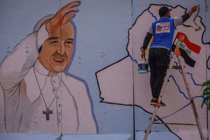21 February 2021, Iraq, Baghdad: Amjad, an Iraqi artist from the "Imprint of Hope" NGO, paints a mural of Pope Francis on the wall surrounding the Sayidat al-Nejat (Our Lady of Deliverance) Syriac Catholic Church. Pope Francis is scheduled for a visit t