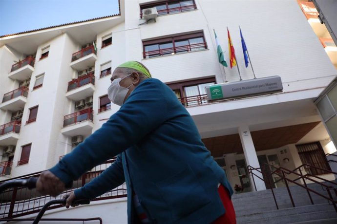 Una anciana sale de un centro residencial para mayores, durante el segundo día en el que los ancianos pueden salir a pasear. En Sevilla, (Andalucía, España), a 16 de febrero de 2021.