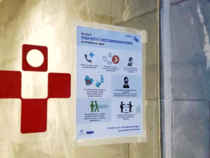 Cartel informativo sobre medidas de seguridad para prevenir el coronavirus, COVID-19, en los centros de Salud. Entrada de Urgencias del Centro de Salud de La Ería, en Oviedo.