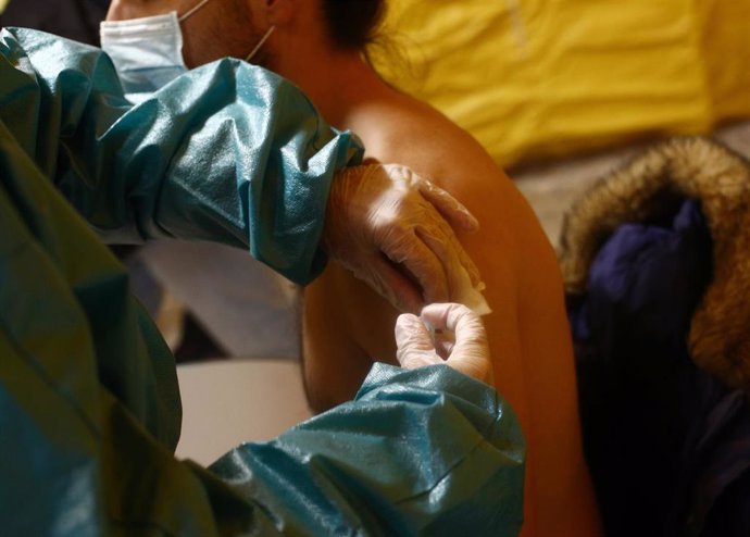 Un trabajador sanitario inyecta la primera dosis de la vacuna AstraZeneca contra el Covid- 19 a un bombero del Ayuntamiento de Madrid, en la Base Cero de la Casa de Campo, Madrid, (España), a 1 de marzo de 2021.