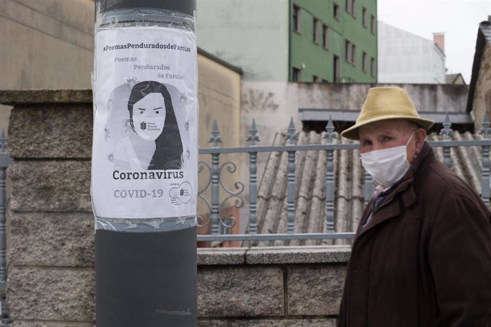 Un anciano pasa junto a una farola con un panfleto alusivo al Covid-19 en el municipio de Guitiriz, Galicia (España), a 26 de febrero de 2021.
