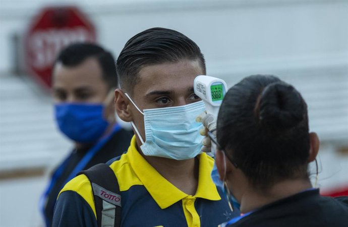 Archivo - Toma de temperatura a un hombre en Managua.