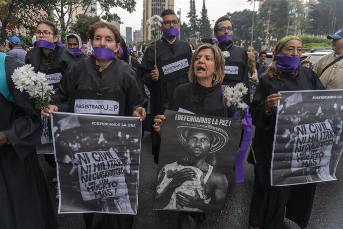 Archivo - Personas con cintas en la boca participan en una manifestación a favor del proceso de paz del país con las exguerrillas de las FARC.