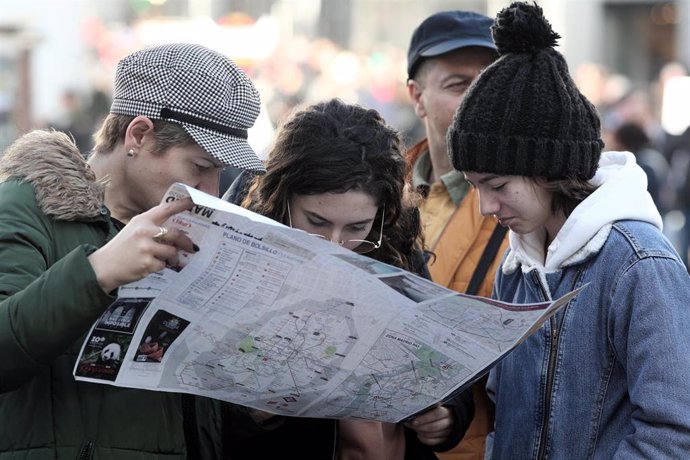 Archivo - Un grupo de turistas consultan un mapa de la ciudad de Madrid.
