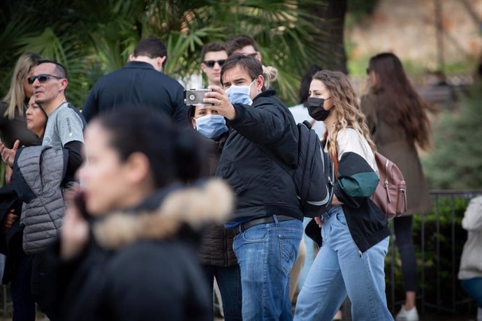 Archivo - Dos personas se hacen un selfie y otra camina en una zona cercana a la Sagrada Familia, en una imagen de archivo