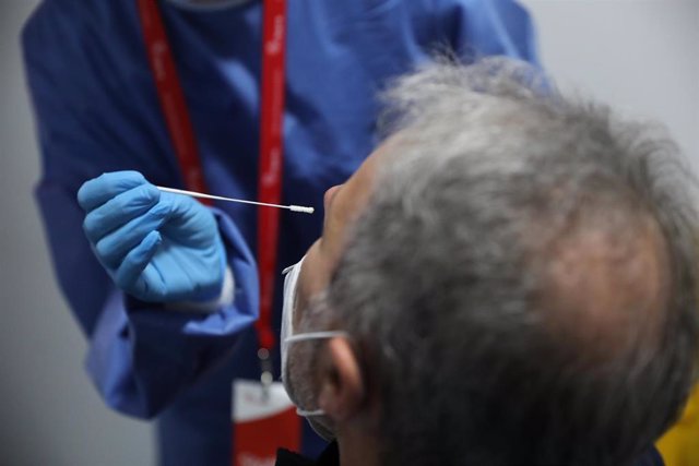 Un sanitario realiza un test de antígenos a un trabajador en la estación de tren de Atocha, Madrid (España), a 22 de febrero de 2021. 