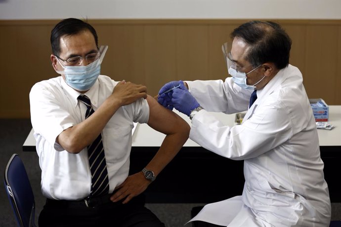 17 February 2021, Japan, Tokyo: Director of the Tokyo Medical Center Kazuhiro Araki (L) receives a dose of coronavirus (COVID-19) vaccine at Tokyo Medical Center as the country launches its inoculation campaign. Photo: Pool/ZUMA Wire/dpa