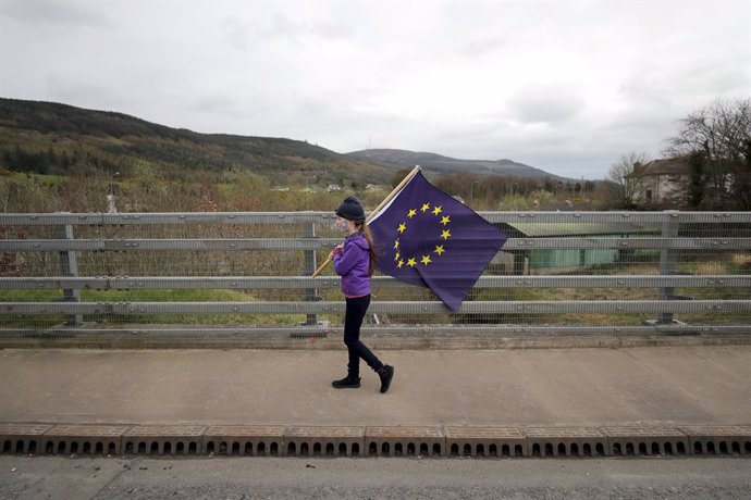 Archivo - FILED - 30 March 2019, Northern Ireland, Carrickcarnon: A girl holds an EU flag during a protest organized by the organisation "Border Communities Against Brexit". Photo: Niall Carson/PA Wire/dpa