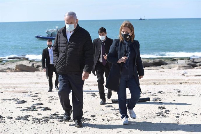 El primer ministro de Israel, Benjamin Netanyahu, y la ministra de Protección Medioambiental, Gila Gamliel, pasean por una playa afectada por los vertidos de petróleo. 
