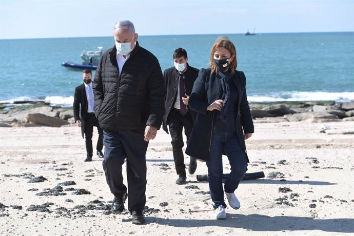 HANDOUT - 21 February 2021, Israel, Ashdod: Israeli Prime Minister Benjamin Netanyahu (L) and Israeli Minister of Environmental Protection Gila Gamliel tour the beach in Ashdod in light of the tar pollution and the subsequent ecological damage. Photo: K