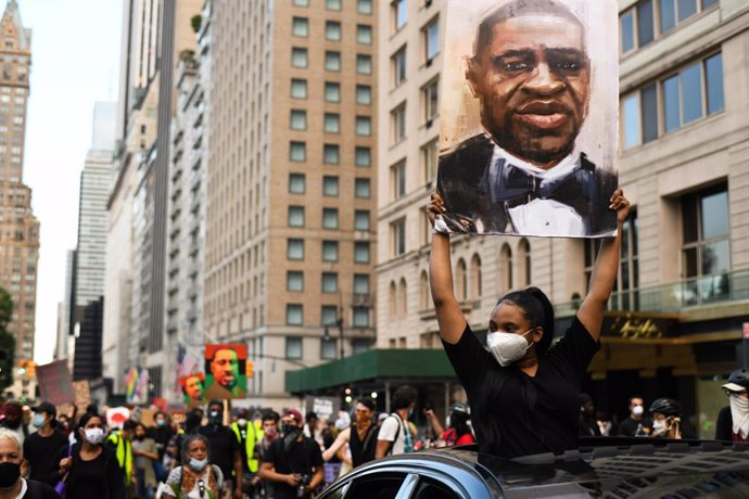 Archivo - 19 June 2020, US, New York: Demonstrators hold pictures of George Floyd, an African American citizen who was killed on 25 May 2020 while in police custody in the US city of Minneapolis, as they march through the streets of Manhattan to commemo