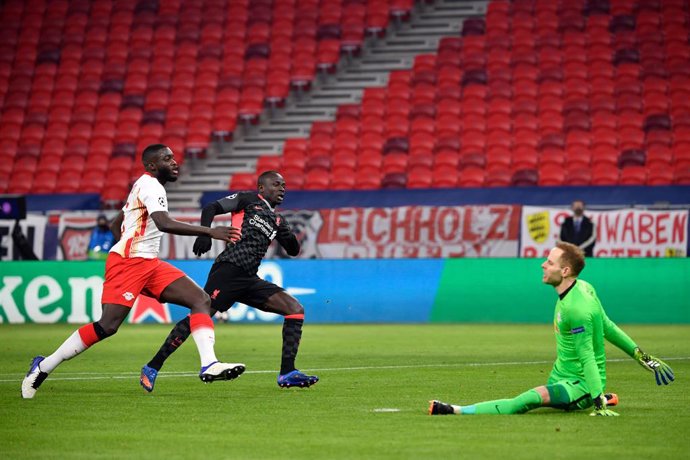 16 February 2021, Hungary, Budapest: Liverpool's Sadio Mane (C) scores his side's second goal past Leipzig goalkeeper Peter Gulacsi during the UEFAChampions League round of 16 first leg soccer match between RB Leipzig and FC Liverpool at Puskas Arena. 