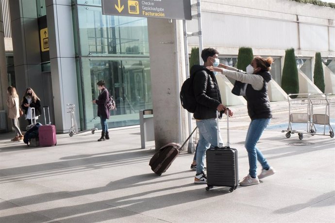 Archivo - Dos personas se abrazan a las afueras del aeropuerto de Palma, días antes de Navidad, cuando comenzó a aplicarse la obligación de presentar PCR negativa para entrar en Baleares desde la Península. 