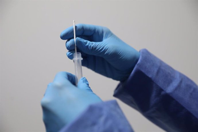 Un sanitario sostiene una probeta tras realizar un test de antígenos a un trabajador en la estación de tren de Atocha, Madrid (España), a 22 de febrero de 2021.
