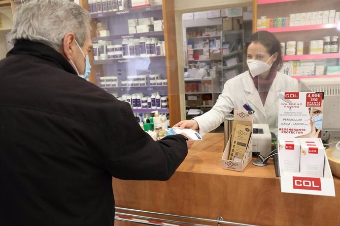 Un anciano recoge una mascarilla FFP2 en la farmacia situada en la C/Tucán (Carabanchel), en Madrid (España), a 4 de febrero de 2021. Los mayores de 65 años de la Comunidad de Madrid pueden recoger a partir de hoy la primera de las dos mascarillas FFP2 
