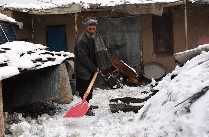 Archivo - Un hombre limpia la nieve en Kabul, capital de Afganistán.
