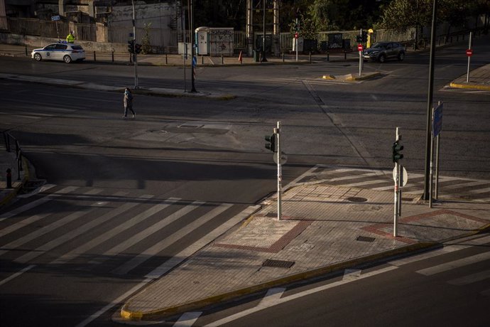 Archivo - 07 November 2020, Greece, Athens: A woman wearing a face mask crosses an empty street at the start of a three week national lockdown for Greece. Greek Prime Minister Kyriakos Mitsotakis said on Thursday that he has ordered the country's second