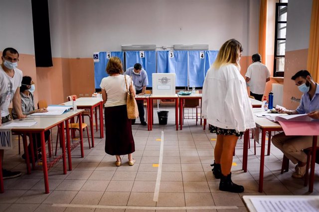 Archivo - Un grupo de personas acude a votar en Milán.