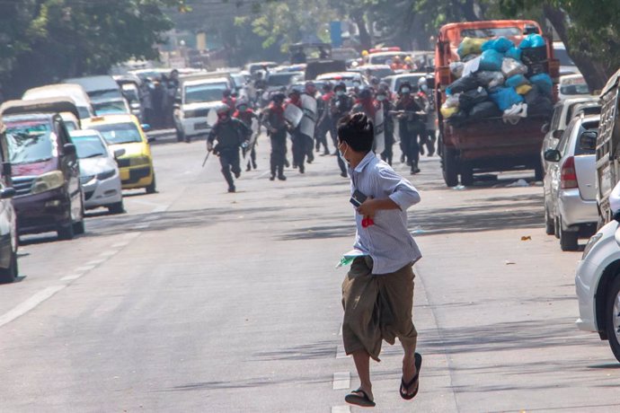 27 February 2021, Myanmar, Rangun: Anti-riot police officers run after a protester during a protest against the military coup and detention of civilian leaders in Myanmar. Photo: Santosh Krl/SOPA Images via ZUMA Wire/dpa