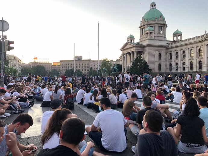 Archivo - 09 July 2020, Serbia, Belgrade: Demonstrators sit on the ground, despite a ban on public gatherings of more than 10 people, during a peaceful sit-in in front of the national parliament against Serbian President Aleksandar Vucic's coronavirus r