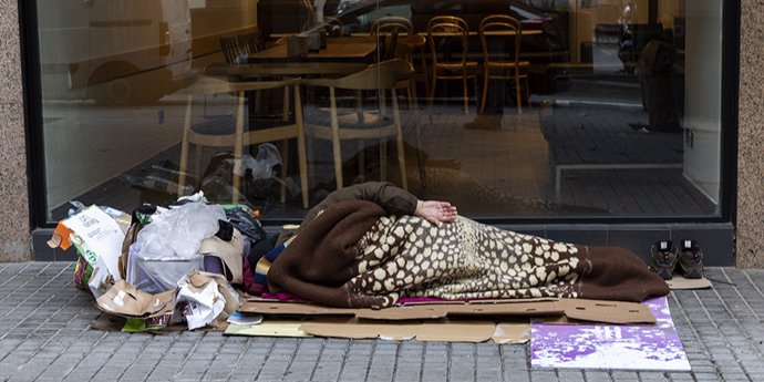 Archivo - Una persona en situación de sinhogarismo durmiendo en la calle