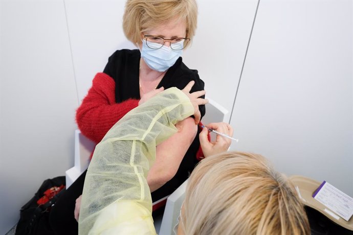 22 February 2021, Belgium, Grace-Hollogne: A woman receives a dose of a COVID-19 vaccine at a vaccination centre. Photo: Bruno Fahy/BELGA/dpa
