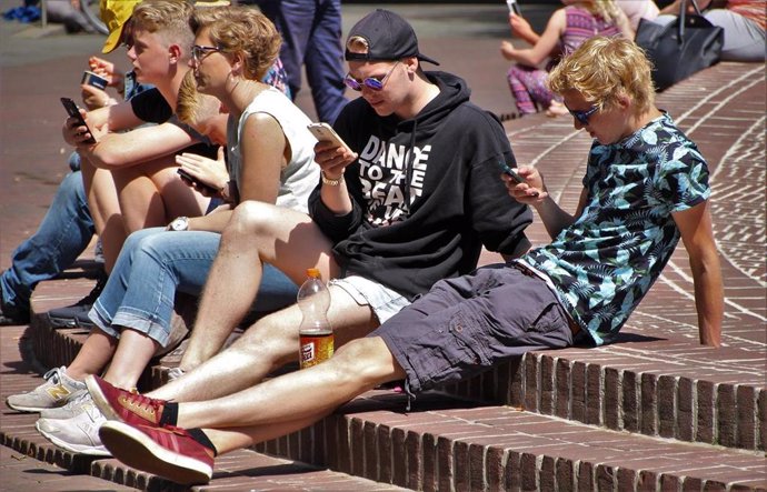 Jóvenes mirando teléfono móvil