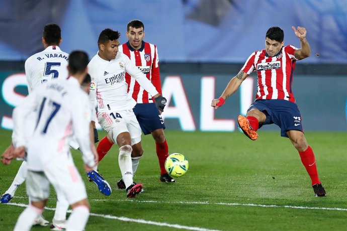 Archivo - Luis Suárez lanza a portería ante Casemiro en el derbi de la primera vuelta