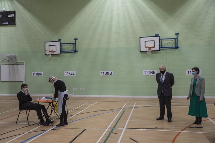 23 February 2021, United Kingdom, London: British Prime Minister Boris Johnson (2nd R) stands in the gym, which is being used as a makeshift coronavirus testing centre for students, during a visit to Sedgehill School. Photo: Jack Hill/The Times via PA W