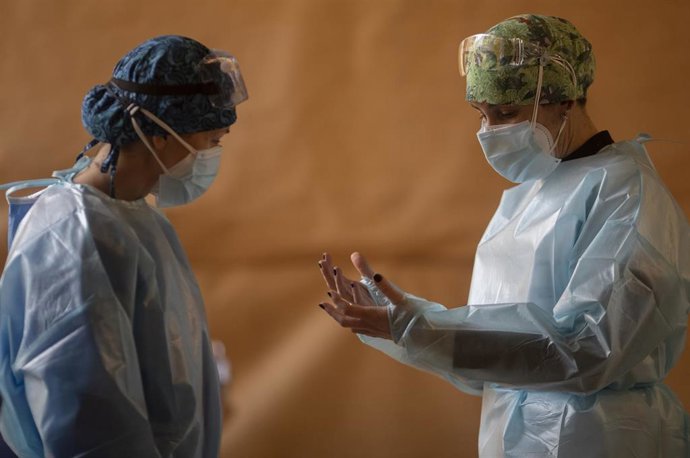 Una trabajadora sanitaria conversa con un compañero en un dispositivo de cribado masivo de antígenos.