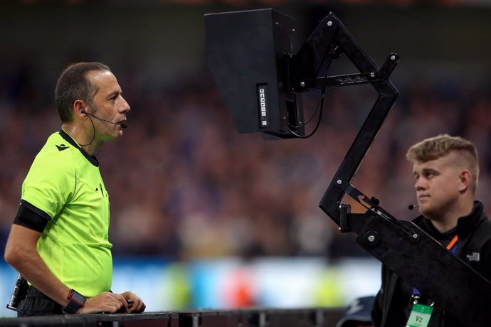 Archivo - 17 September 2019, England, London: Referee Cuneyt Cakir (L) checks the pitch side tv camera to check a VAR decision before awarding a penalty during the UEFA Champions League Group H soccer match between Chelsea and Valencia at Stamford Bridg