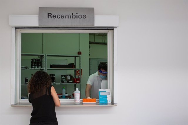 Archivo - Un empleado atiende a una clienta en un concesionario.