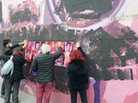 Colectivos vecinales cubren la pintura negra del mural de Ciudad Lineal con reproducciones de los rostros de las mujeres