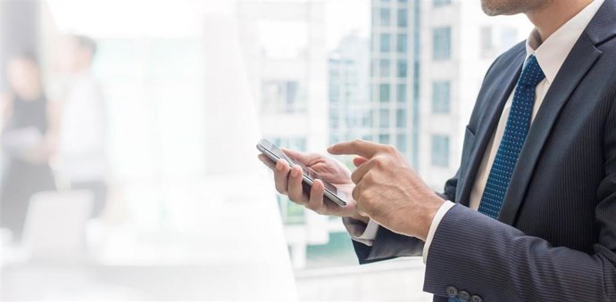 Un ejecutivo mirando su teléfono móvil